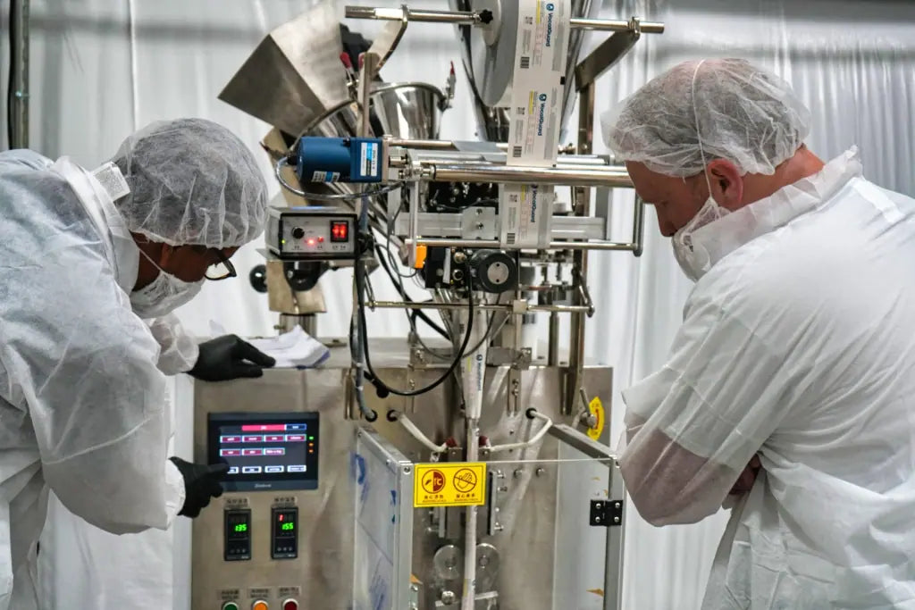 Operators inspecting Go Wise production equipment in a clean facility